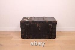 A vintage black wooden trunk with hinged lid blanket box log storage