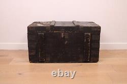 A vintage black wooden trunk with hinged lid blanket box log storage