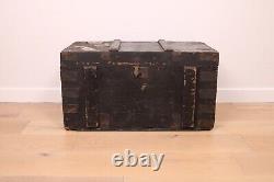 A vintage black wooden trunk with hinged lid blanket box log storage