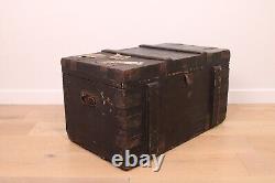 A vintage black wooden trunk with hinged lid blanket box log storage