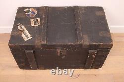 A vintage black wooden trunk with hinged lid blanket box log storage