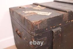 A vintage black wooden trunk with hinged lid blanket box log storage