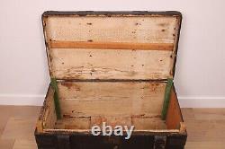 A vintage black wooden trunk with hinged lid blanket box log storage