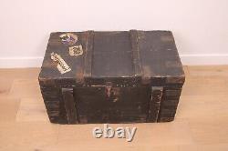 A vintage black wooden trunk with hinged lid blanket box log storage