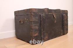 A vintage black wooden trunk with hinged lid blanket box log storage